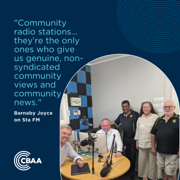 A quote from the article and a photo of Barnaby Joyce and David Gillespie sitting at the studio desk with Sta FM workers standing beside them